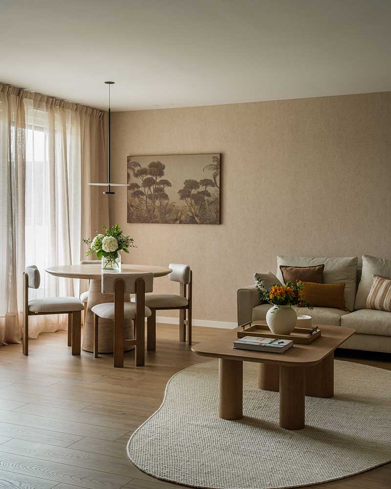 Vista del salón y comedor de Casa Kane con mobiliario en madera y tonos neutros